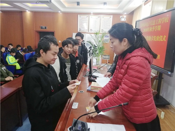 7张丽君主任核对信息并将资助卡发放给学生.jpg